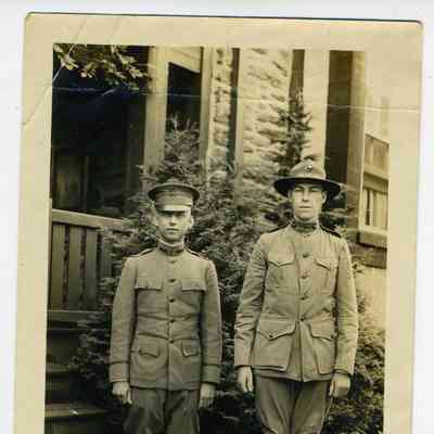 Photograph of two soldiers in front of a house