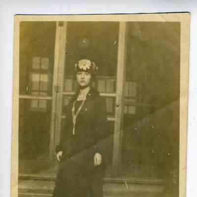 Photograph of a young woman on the steps in front of a building