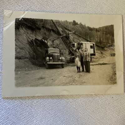 Three People in front of Car and Excavator