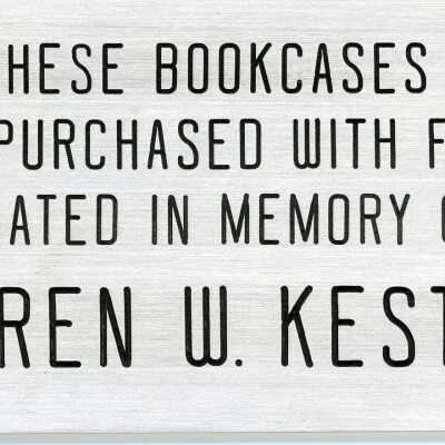 Metal plaque acknowledging the donation of 3 metal display cases in memory of Warren W. Kester.