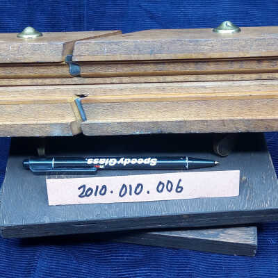 The cutting blades: Underside of the plane showing the cutting edges of the two irons, a skewed straight rebate iron at the bottom, and an ogee iron at the top.