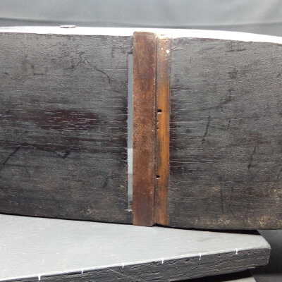 Steel? mouth set in with wooden wedge in dovetail housing.