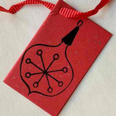 Front of silkscreened gift tag attached to crimped hanging ribbon.