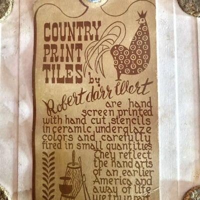 Back of tile with Country Print Tiles label hanger and cork pads.