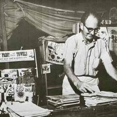 Retail display banner at left. Robert Darr Wert at the Country Prints display and demonstration at the Eastern States Exposition, Massachusetts, 1965.: Image: Collection of Sara Leeper.