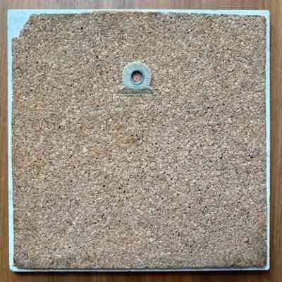 Tile back with cork pad and hanging tab.