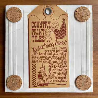 Back of tile with cork pads and Country Print Tiles label hanger.
