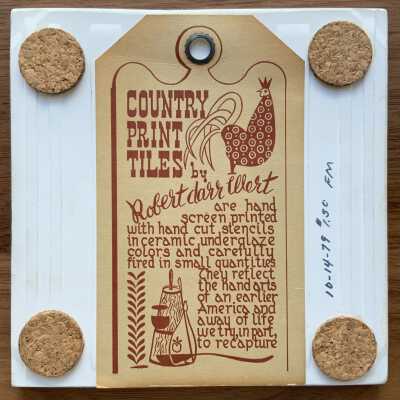 Back of tile with Country Print Tiles label hanger and cork pads.
