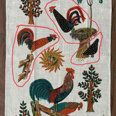 Wallhanging: Good Morning U226. Circled red rooster and black hen appear on the cross stitch apron.: PKM collection.