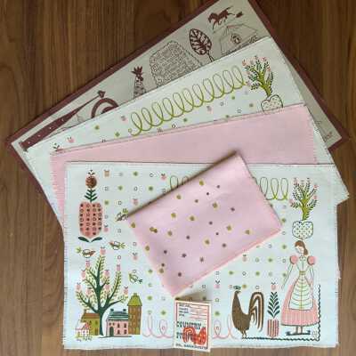 Complete set: Two placemats, two oversized napkins (pink), and Country Prints backing board. Original poly sleeve included but not shown. PKM collection.