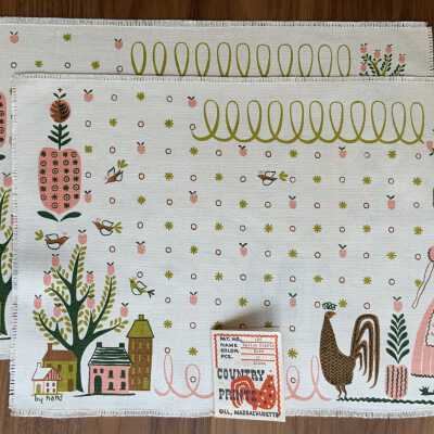 Two placemats with a Country Prints product tag.