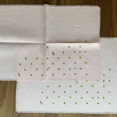 Two pink napkins with asymmetrical design of hearts and stars.