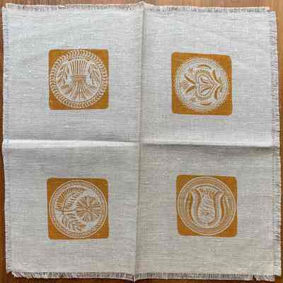 Matching square napkin with buttermolds centered in each quadrant.