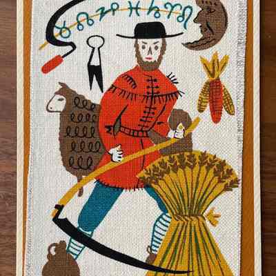 Harvest: A farmer in a fringed buckskin coat holds a scythe and stands amongst symbols of harvest season: a shock of wheat, dried corn, a sheep with shears, and a jug for cider. Zodiac symbols follow a crescent moon through the sky above, a nod to The Farmers Amanac. The crescent moon indicates the late nights of harvest season. (Six colors)