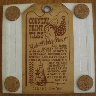 Back of tile with Country Print Tiles label hanger and cork pads.
