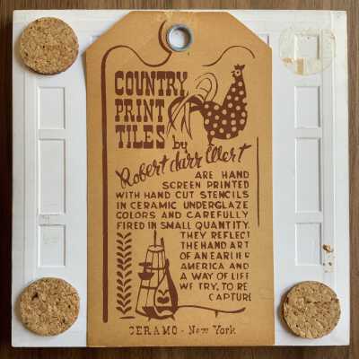 Back of tile with Country Print Tiles label hanger and cork pads.