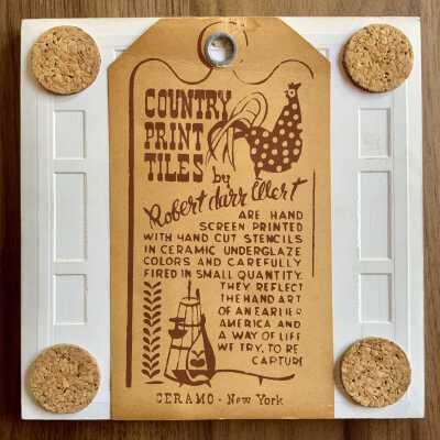 Back of tile with Country Print Tiles label hanger and cork pads.