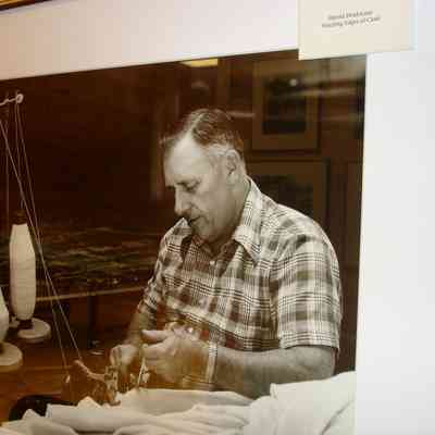 Harold Drinkwater stitching edges of cloth at the Knox Mill