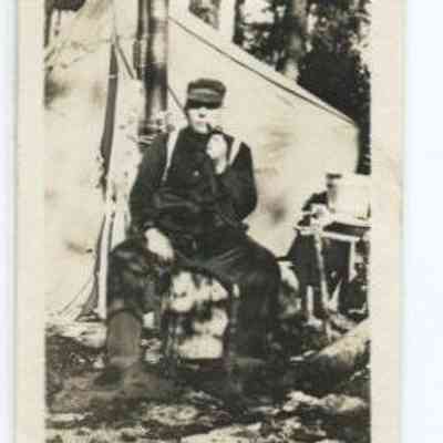 Man smoking a pipe at a woodland campsite: Origformat: Print-Photographic; Resolution: 150