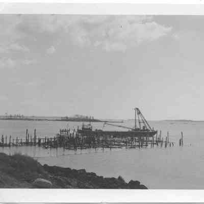 Eastern Steamship wharf burned pilings with barge nearby