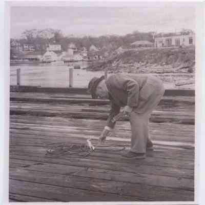 Andrew Sides strikes a match on the Eastern Steamship wharf