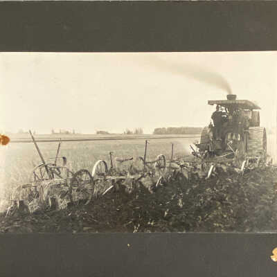 Steam-powered tractor pulling five plows