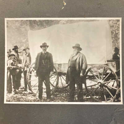 Two Men in Front of Covered Wagon