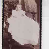 Infant in Long Christening Gown Seated on Ornate Bench — Studio Portrait