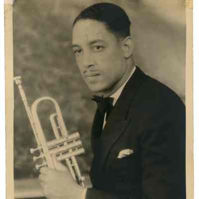 2022.057.030 Recto: Black and white photograph by Horace Brazelton of an unknown man holding a trumpet