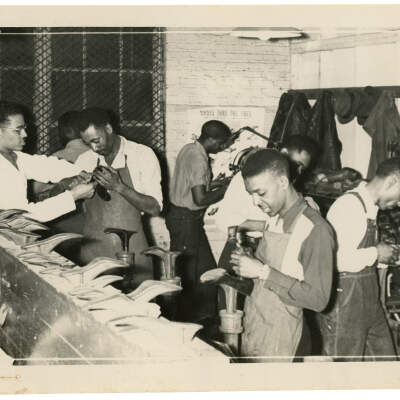 2022.024.014 A Recto: Black and white photograph of a shoe repair class at Boone Higgins Trade School