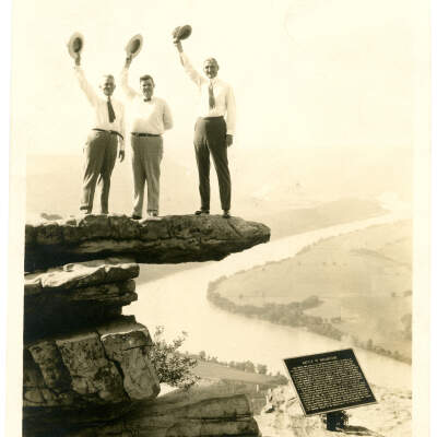 Three Men Standing on Umbrella Rock Photograph