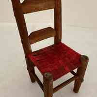 Wooden chair, with red, caned seat.
