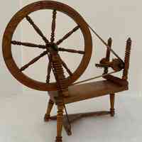 Wooden  carved spinning wheel with movable wheel and pedal.