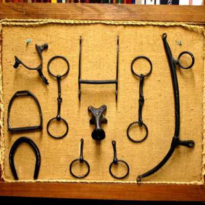 10 Items on a Display board Items are related to Horse use. Stirrup, Horse Shoe, Bits, Saddle Horn, Spur