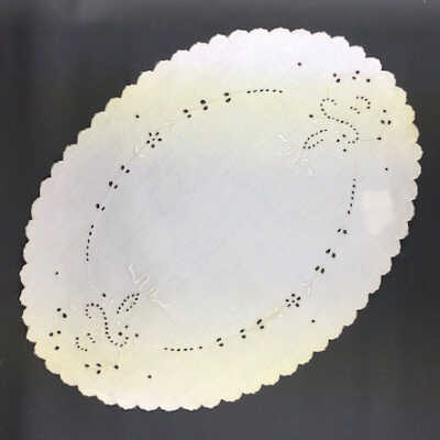 Oval white inen doily with machine embroidery, c. 1915-1920s