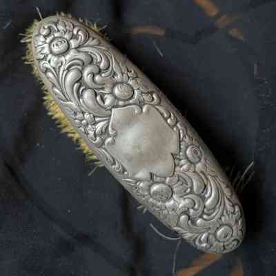 Oval brush with silver grip and design of entwining leaves, c. 1900