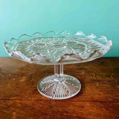 Clear patterned glass compote or cake stand on round pedestal base, c. 1910