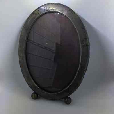Oval silver picture frame on ball feet of the toye family, early 1900s