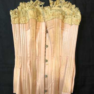 Pink satin covered corset with ecru trim and white silk lacing, 1895