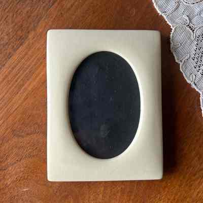 Rectangular Celluloid frame with circular opening and purple velvet backing, 1915-1920
