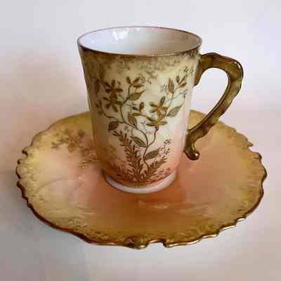 Elite Limoges porcelain demitasse cup and saucer with raised flowers and leaves, c. 1900