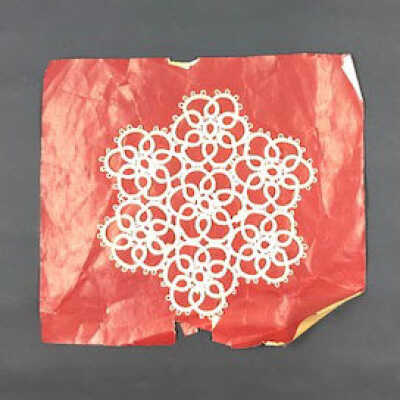 Crocheted doily on original red paper mounting, c. 1910-1920