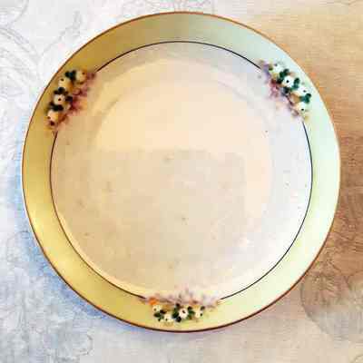 Porcelain plate with rainbow rinse and pale green border with flowers, 1915-1920
