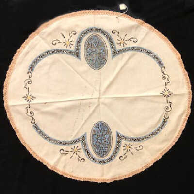 Circular linen table cloth with embroidery in blue, black, and yellow, c. 1930s
