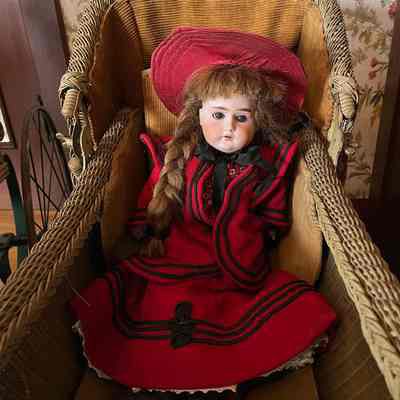 Bisque doll with brown wig in red costume, 1900