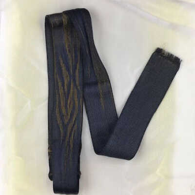 Black silk tie woven over gold background of Wm. Cox Sr., early 1900s