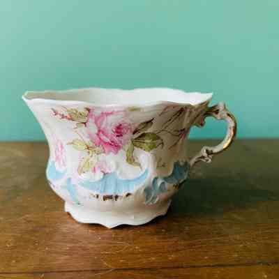 Weimar porcelain cup and saucer with roses and blue trim, early 1900s