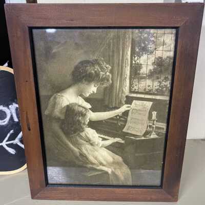 Framed photolithographic print of a woman and child at a piano, c. 1900