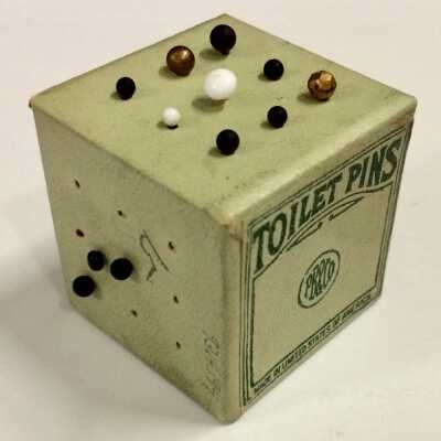 White and black porcelain headed toilet pins in green cardboard box, c. 1920s