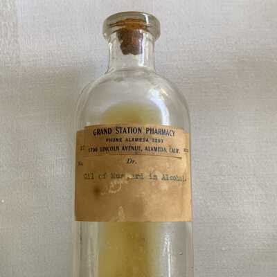 Clear pressed glass medicinal bottle from Grand Station Pharmacy, 1900s to 1920s